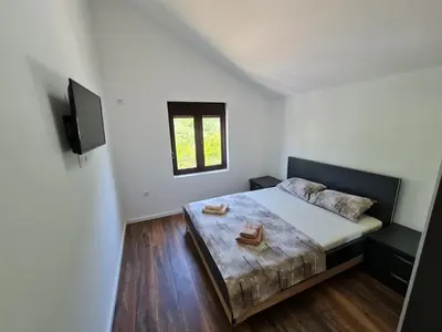 a bedroom with a large bed and a television at Luxury Penthouse with panoramic view in Ulcinj