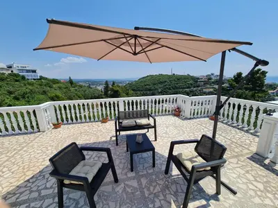 a patio with two chairs and an umbrella at Luxury Penthouse with panoramic view in Ulcinj
