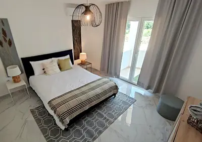 a bedroom with a bed and a large window at Villa Olive Hill in Dobra Voda