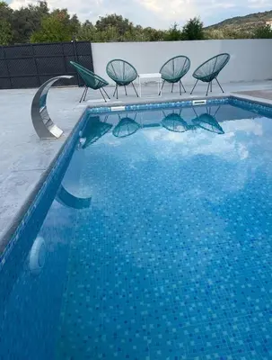 a swimming pool with chairs and a swimming pool at Villa Olive Hill in Dobra Voda