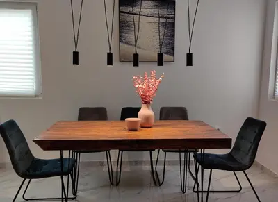 a dining room table with chairs and a vase with flowers at Villa Olive Hill in Dobra Voda