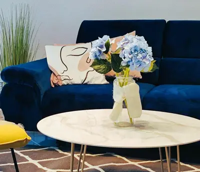 a vase with blue flowers sitting on a table at Villa Olive Hill in Dobra Voda