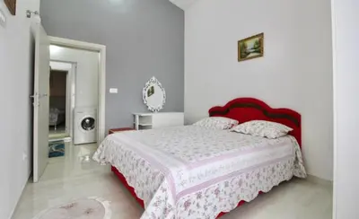 a bedroom with a large bed with a red headboard at Apartment ANA in Bar