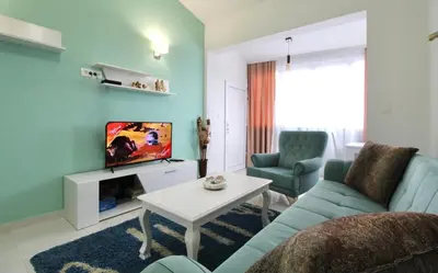 a living room with a blue couch and a tv at Apartment ANA in Bar