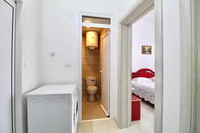 a small bathroom with a toilet and a bedroom at Apartment ANA in Bar