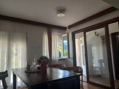 a dining room with a table and chairs and a window at Konak Ugnji-Village in Cetinje