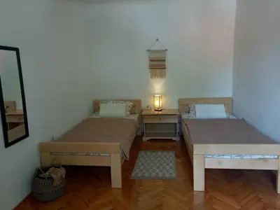 a room with two beds and a table with a lamp at Konak Ugnji-Village in Cetinje