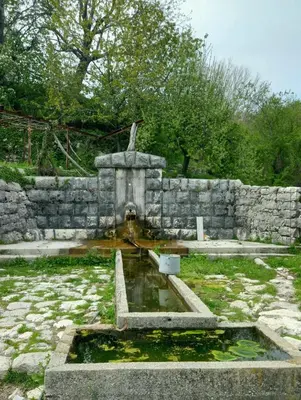 a stone fountain in front of a stone wall at Konak Ugnji-Village in Cetinje