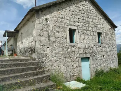 an old stone building with stairs in front of it at Country stone house Kovacevic in Danilovgrad