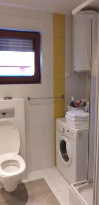 a bathroom with a toilet and a washing machine at Stan u centru BEST VIEW in Bar