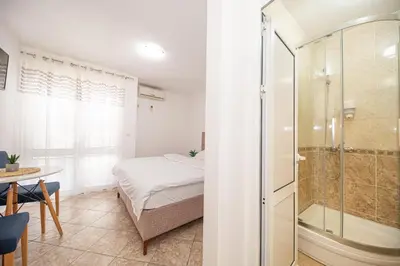 a bedroom with a bed and a glass shower at Villa Dana in Bar