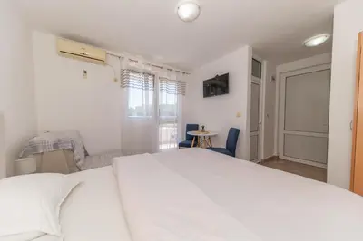 a bedroom with a large white bed and a window at Villa Dana in Bar