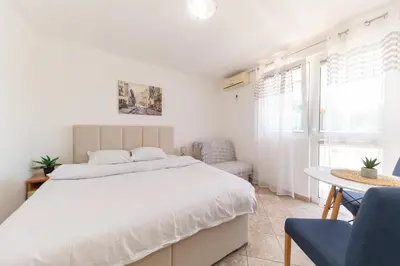 a bedroom with a large white bed and a table at Villa Dana in Bar