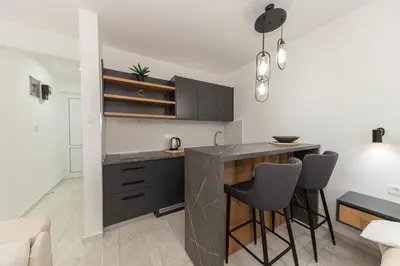 a kitchen with a counter and stools in a room at Villa Dana in Bar