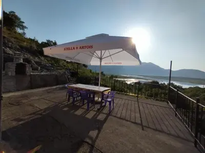 a table and chairs under a white umbrella at The Island of Prevlaka in Prevlaka