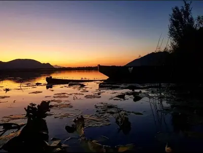 a boat sitting on the water at sunset at The Island of Prevlaka in Prevlaka