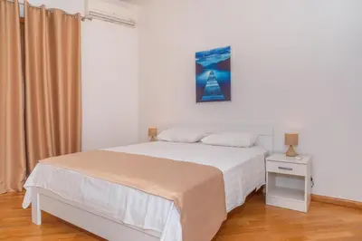 a white bedroom with a bed and a picture on the wall at Alex Lux sea view aparmtent 2 in Rafailovici