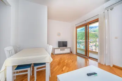 a white room with a table and a television at Alex Lux sea view aparmtent 2 in Rafailovici