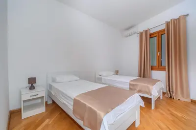 a bedroom with two beds and a window at Alex Lux sea view aparmtent 2 in Rafailovici