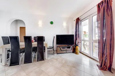 a dining room with a table and chairs and a television at Holiday Home Adria in Dobra Voda