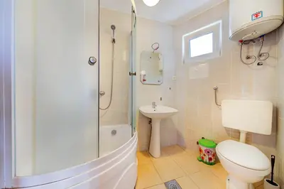 a bathroom with a shower and a toilet and a sink at Holiday Home Adria in Dobra Voda