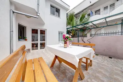a table with a vase of flowers on a patio at Holiday Home Adria in Dobra Voda