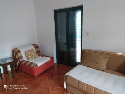 a living room with a couch and a chair at Apartman Podkošljun in Budva