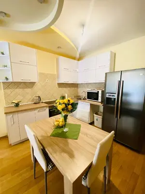 a kitchen with a wooden table and a refrigerator at 'M&M' two bedroom apartment in center of Budva in Budva