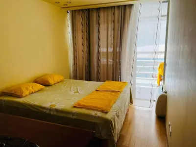 a bedroom with a bed with yellow sheets and a window at 'M&M' two bedroom apartment in center of Budva in Budva