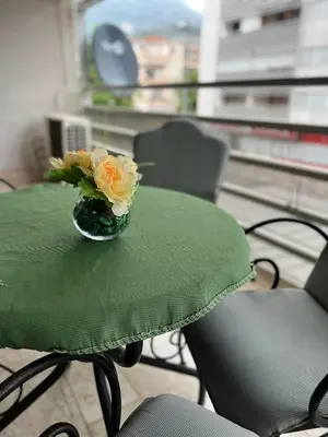 a green table with a vase of flowers on it at 'M&M' two bedroom apartment in center of Budva in Budva