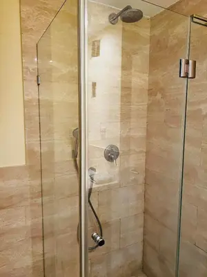 a shower with a glass door in a bathroom at 'M&M' two bedroom apartment in center of Budva in Budva