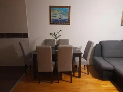 a dining room with a table and chairs and a couch at Marija in Bar