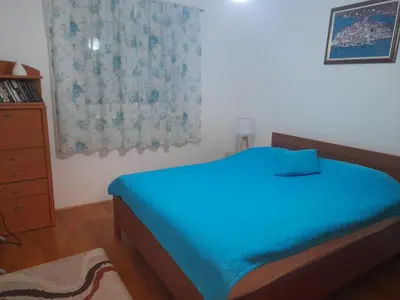 a bedroom with a blue bed and a window at Marija in Bar