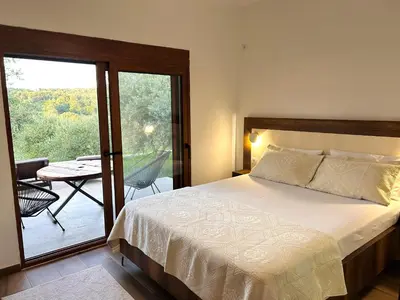 a bedroom with a bed and a balcony with a table at Greenscape Village in Ulcinj