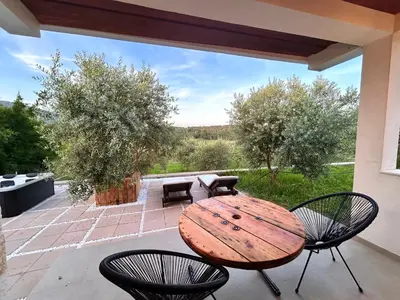 a wooden table and chairs on a patio at Greenscape Village in Ulcinj