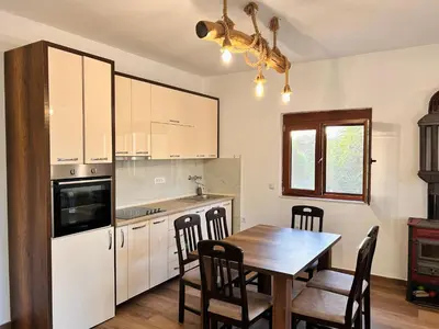 a kitchen with a wooden table and a dining room at Greenscape Village in Ulcinj