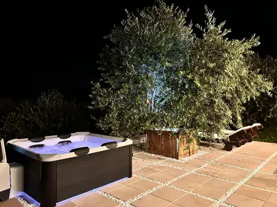 a hot tub sitting on a patio with two trees at Greenscape Village in Ulcinj