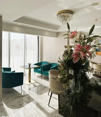 a lobby with blue chairs and a vase of flowers at Montenegrina Hotel & SPA All-Inclusive in Becici