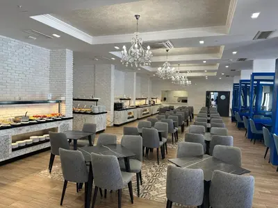 a restaurant with a row of tables and chairs at Montenegrina Hotel & SPA All-Inclusive in Becici