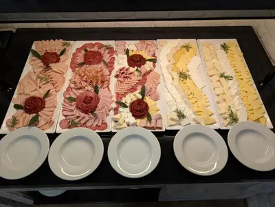 a table with white plates and flowers on it at Montenegrina Hotel & SPA All-Inclusive in Becici