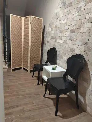 two chairs and a table in a room with a brick wall at Montenegrina Hotel & SPA All-Inclusive in Becici