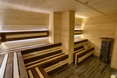 a wooden sauna with wooden benches in a room at Montenegrina Hotel & SPA All-Inclusive in Becici