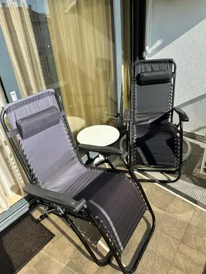 a rocking chair sitting on a balcony next to a window at SOHO JC Apartment in Bar