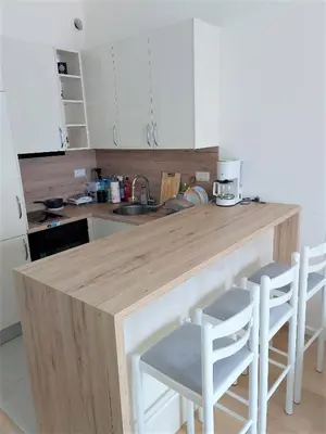 a kitchen with a wooden counter and stools in it at SOHO JC Apartment in Bar