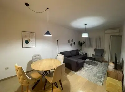 a living room with a table and a couch at Vista City Apartment in Podgorica