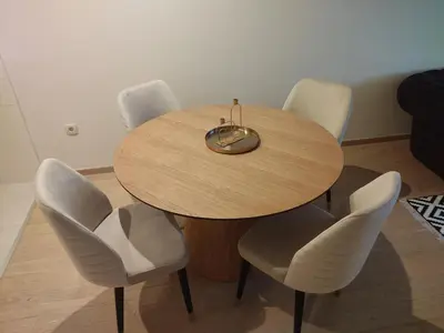 a wooden table with four white chairs around it at Vista City Apartment in Podgorica