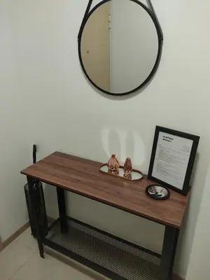 a wooden table with a mirror on a wall at Vista City Apartment in Podgorica