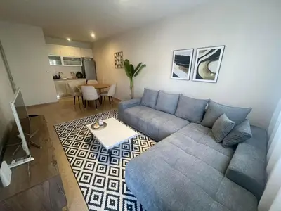 a living room with a blue couch and a table at Vista City Apartment in Podgorica