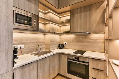 a kitchen with wooden cabinets and a sink and a microwave at Royal Residence Apartment in Budva