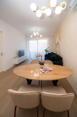 a dining room table and chairs in a living room at Royal Residence Apartment in Budva